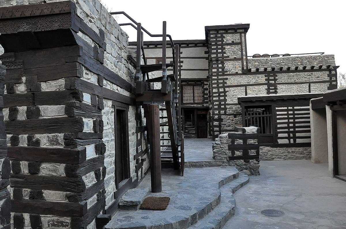 Stone and timber walls and wooden stairs in the courtyard of Shigar Fort